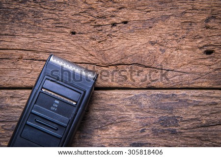 Electric shaver on wood background