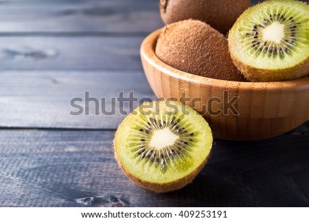 Kiwi fruit in a bowl on wooden background. Copy space