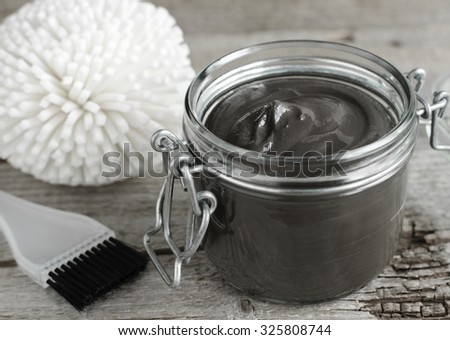 Black volcanic cosmetic clay in a glass jar