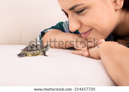 Close-up shot of a young girl looking at a little turtle
