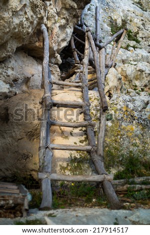 Old wooden ladder on a background of rocks