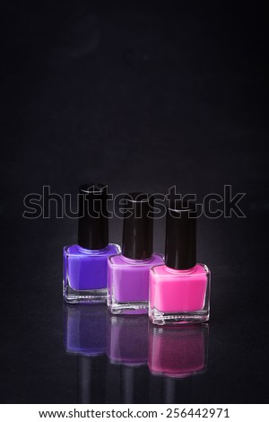 rainbow of nail polishes on a black background