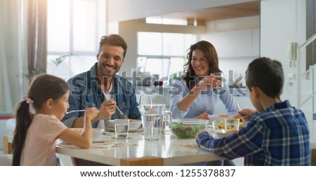 Portrait of happy family having lunch in dining room. Concept of healthy food, wellbeing, happy family