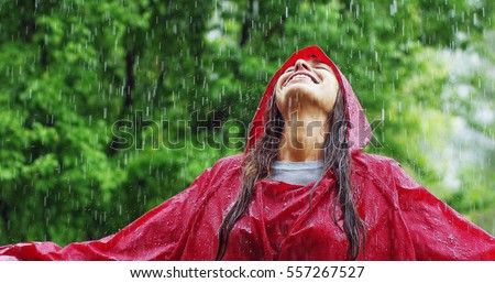 girl smiles, spins and laughs in the rain. the rain falls, the drops fall on his face and the girl is happy with life and nature around. concept of nature and happy life. Adventure, purity.