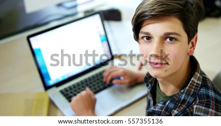 Young boy student, studying computer and is happy to learn new things