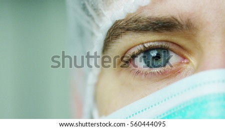 close up portrait of a surgeon or doctor with mask and headset ready for operation in hospital or clinic. The surgeon smiles safe and proud of himself. Concept of medicine, hospitals and doctors, care