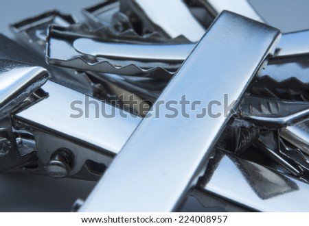 Pile of steel crocodile clips with smooth metallic surface