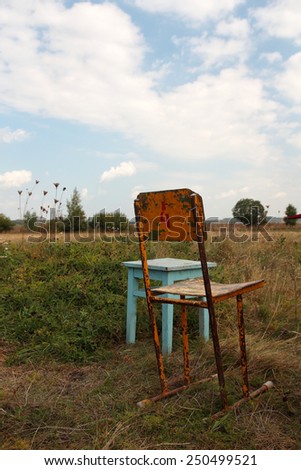 Two old rusty chairs in the field.