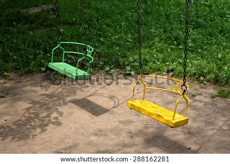 Yellow and green swing on iron chains