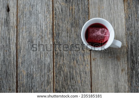 Hot tea in a white mug against a wood background