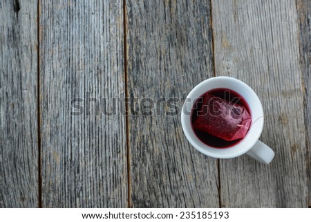 Hot tea in a white mug against a wood background