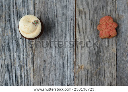 Gingerbread Man Cupcake with three Cookies Stacked on Wood Background