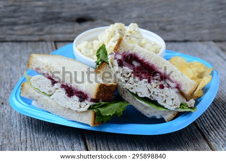 Homemade Leftover Thanksgiving Dinner Turkey Sandwich with Cranberries on Wood