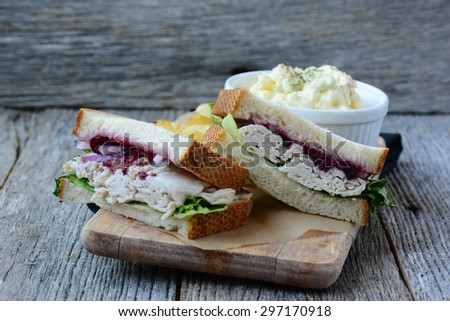 Homemade Leftover Thanksgiving Dinner Turkey Sandwich with Cranberries on Wood