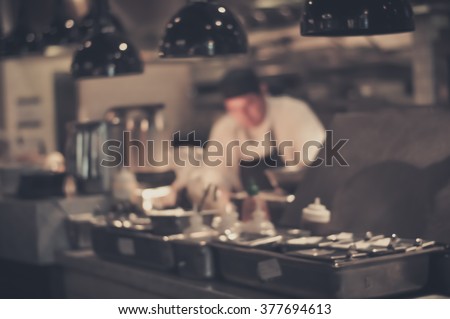 Blurred Restaurant chef: Chef cooking in the open kitchen, customer can see they cooking at food counter
