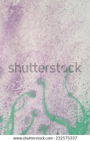 streaks of green paint on paint purple with a round end