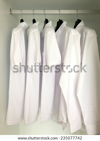 white shirts hanging on cloths racks