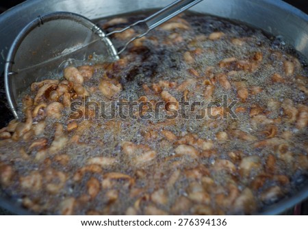 chicken deep frying in oil in a cast iron frying