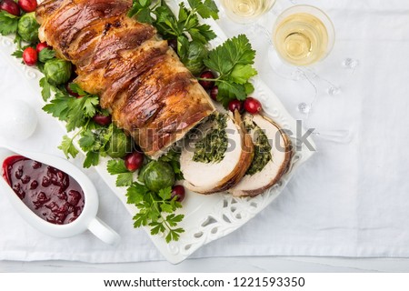 bacon wrapped turkey breast stuffed with spinach and cheese for festive dinner, white background, top view, copy space