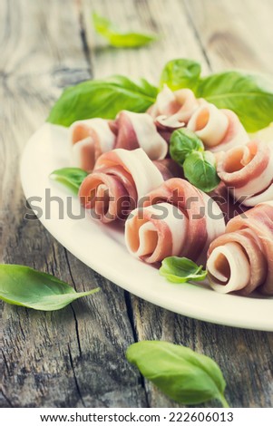 Prosciutto with basil on a white plate