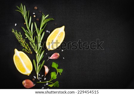 Black food background with fresh aromatic herbs and spices, copy space, top view