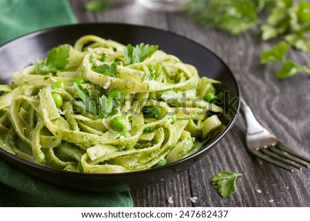 Tagliatelle pasta with spinach and green pea pesto, selective focus