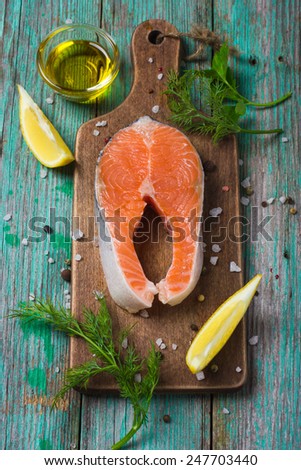 fresh raw salmon steak with herbs and spices, top view