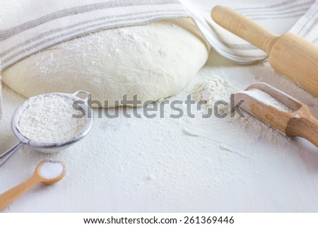 baking background.  Flour, bake ware and  dough on white wooden table