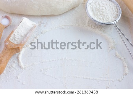 baking background.  Flour, bake ware and  dough on white wooden table