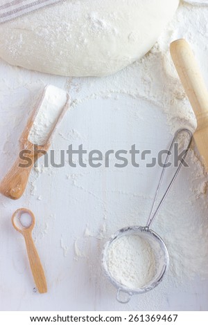 baking background.  Flour, bake ware and  dough on white wooden table, top view