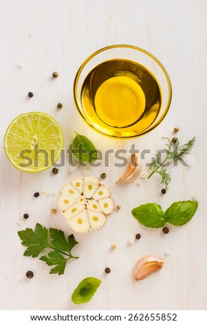 Ingredients for salad dressing. Olive oil, garlic, lemon, herbs and spices on white background, top view