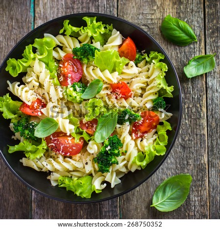 Pasta salad with cherry tomatoes and broccoli, top view, square image