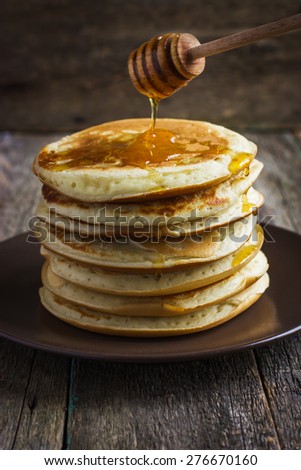 pancakes with honey on wooden background