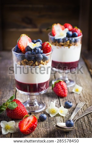 dessert with fresh berries,  cream cheese, granola and berries  jam on rustic background