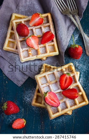 belgian waffles with fresh strawberry on dark blue background, top view