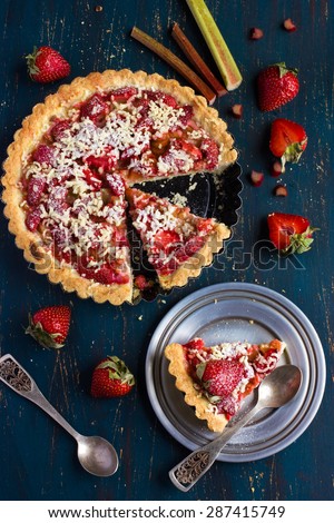 Rhubarb and strawberry cake on dark background, top view