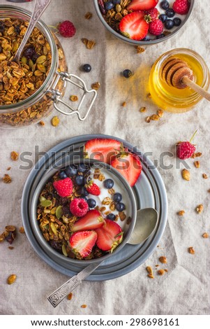 Healthy breakfast. Granola with fresh berries and  yogurt  on rustic background, top view