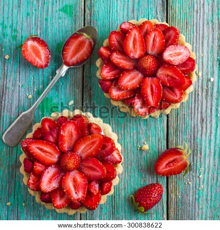 Tart with fresh strawberry on wooden background, top view, square image