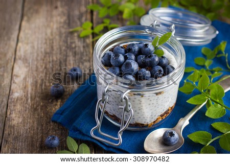 Pudding  with chia seeds, granola and fresh blueberry in glass jar