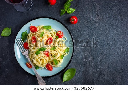 Spaghetti pasta  with cherry tomatoes,  basil and parmesan cheese, top view, copy space