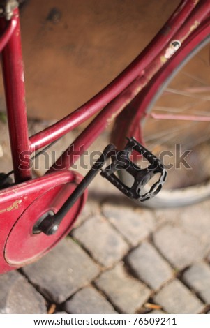 vintage red bike on a cobbled road