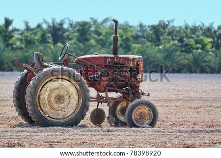 Old rusty tractor sitting in a field to do the work even after all those years