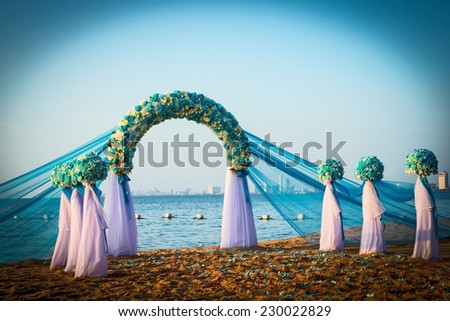 white and blue wedding arch on the beach