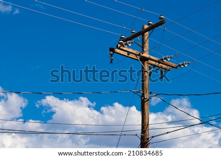 wooden pole with wires against the blue sky