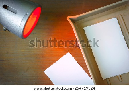 Photographic paper shows up in a cuvette and red laboratory lantern