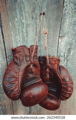 Old boxing gloves hanging on a wooden wall