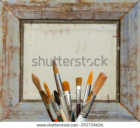 Brushes for painting in the artist\'s studio on the background of a wooden frame
