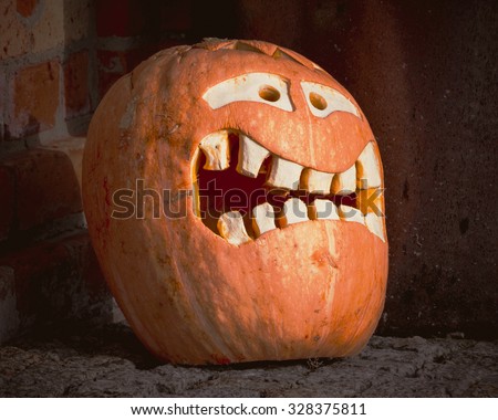Halloween.The mask of pumpkin on a background of a brick wall