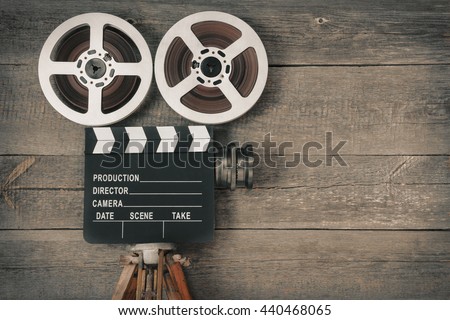 Old movie camera, consisting of a tripod, lens, film reels and clapperboards
