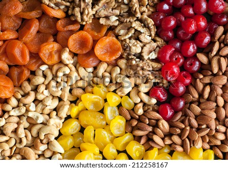 dried fruits and nuts on black background .